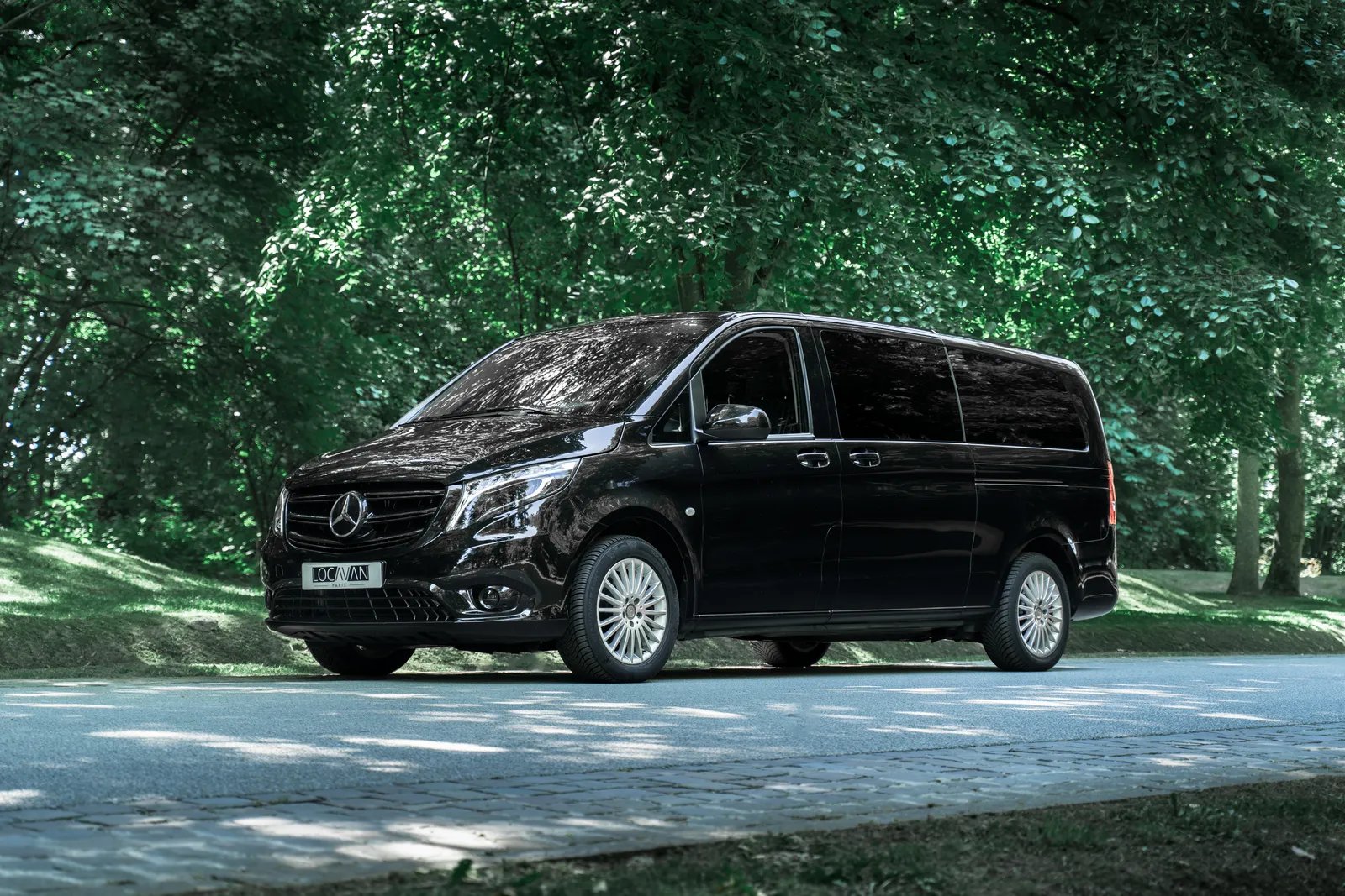 Minibus Mercedes Vito Tourer Locavan, de trois quarts, sur une route en forêt