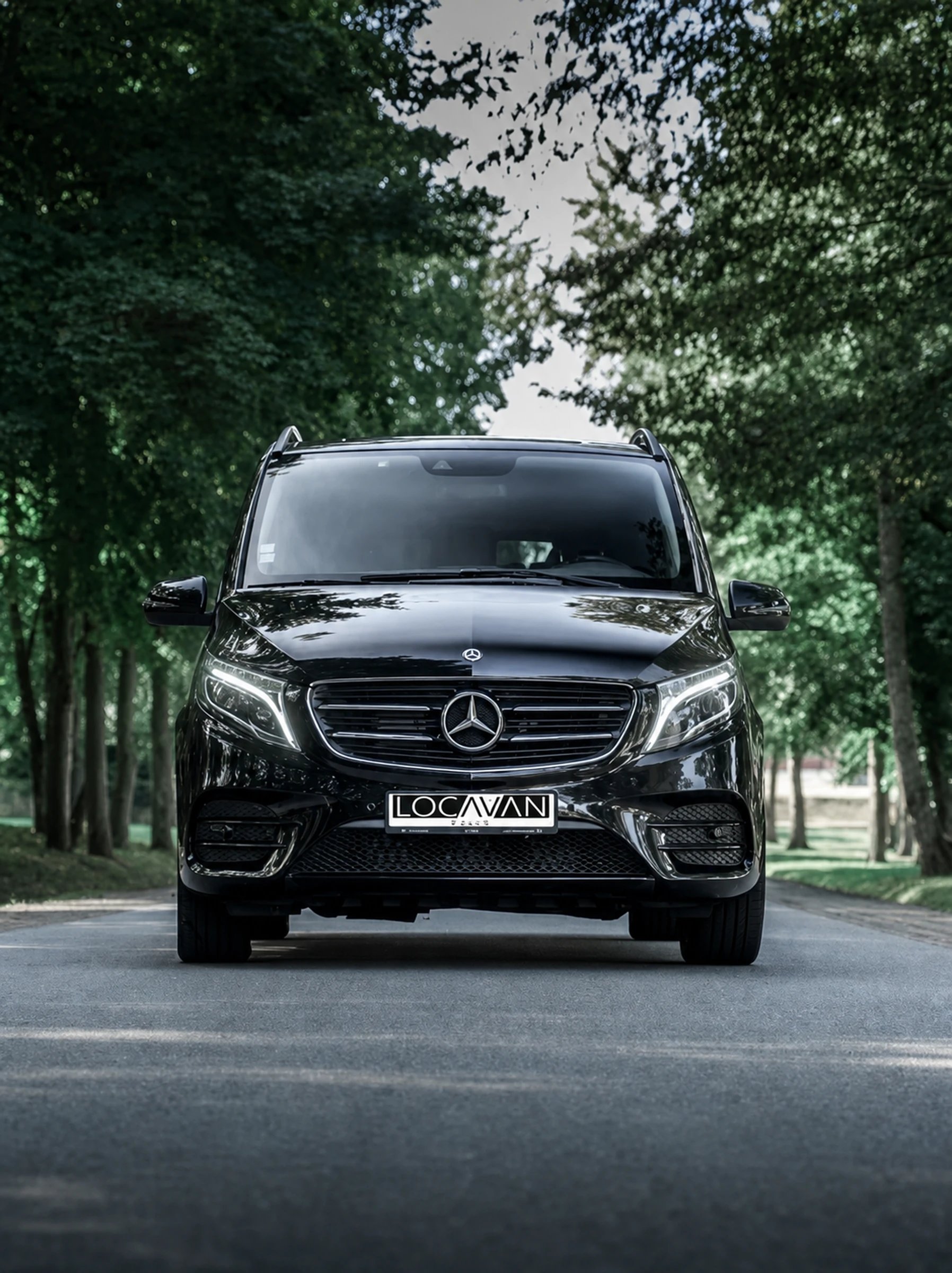Van Mercedes Classe V Locavan, de face, sur une allée boisée
